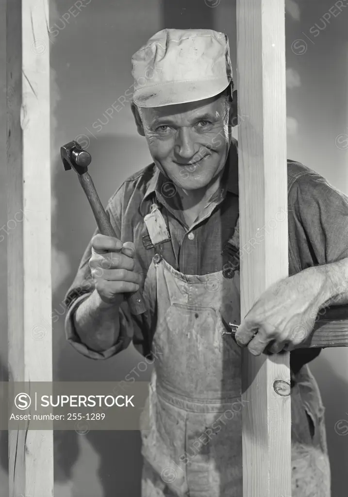 Vintage Photograph. Carpenter holding hammer and nails smiling