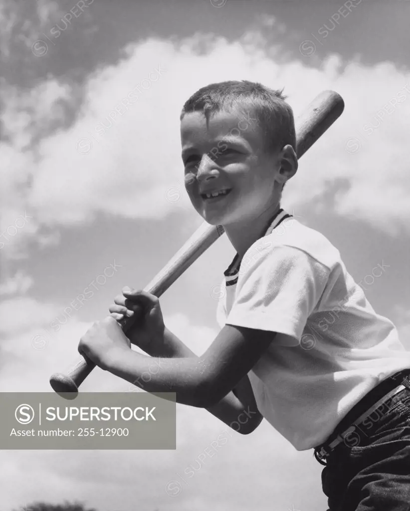 Low angle view of a boy swinging a baseball bat
