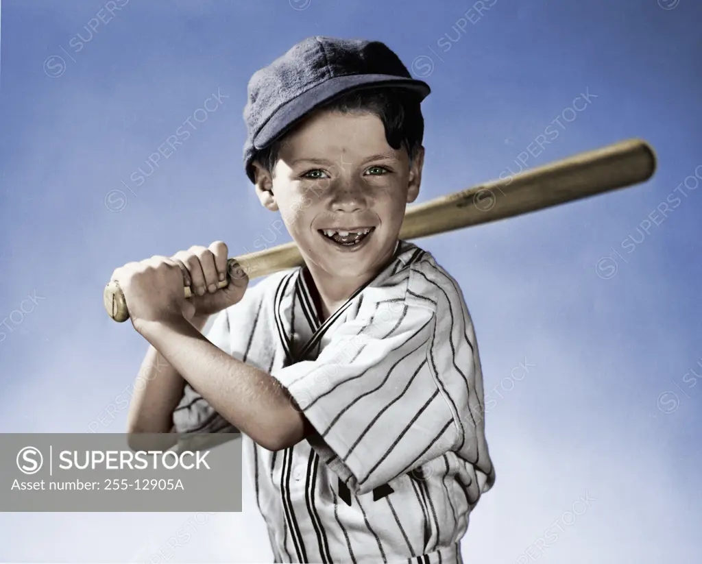 Colorized Vintage Photograph. Young boy wearing baseball uniform holding bat over shoulder