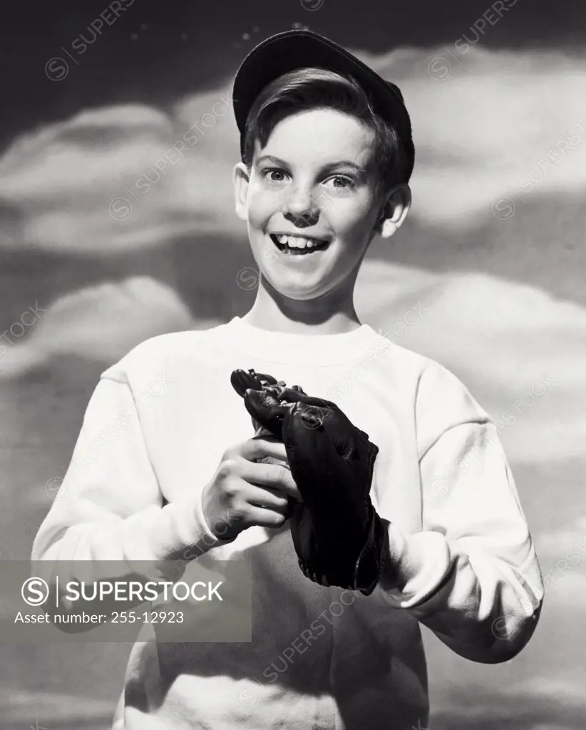 Portrait of a smiling boy holding a baseball and baseball glove