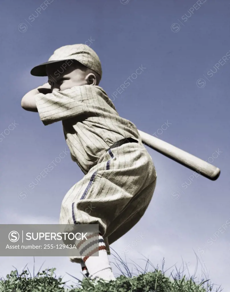 Side profile of a boy swinging a baseball bat