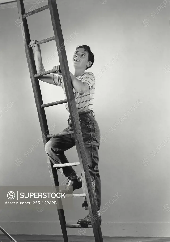 Vintage photograph. Boy smiling climbing wooden ladder