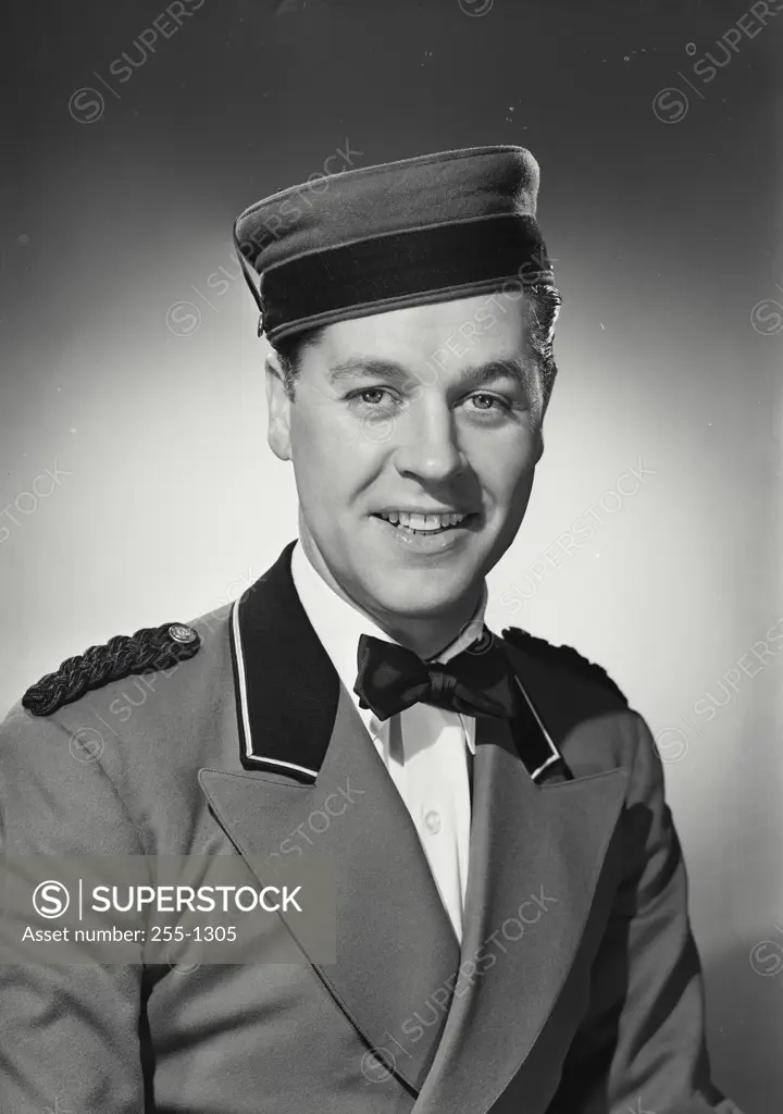 Vintage Photograph. Smiling bellman wearing uniform