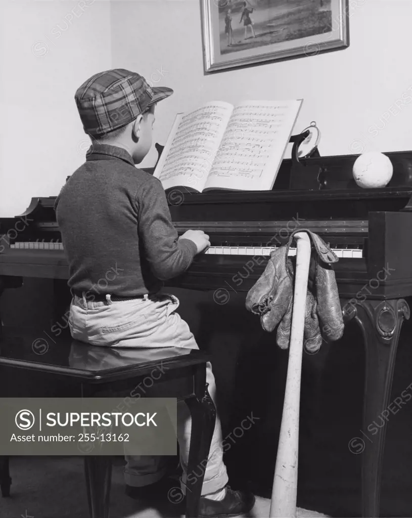 Rear view of a boy playing a piano