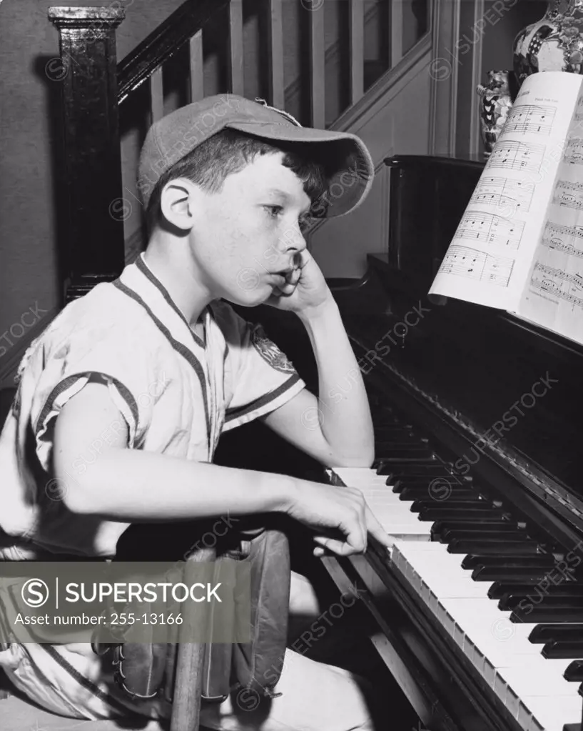 Side profile of a boy playing a piano
