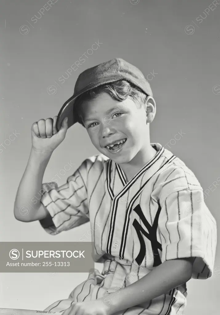 Vintage Photograph. Young boy wearing New York Yankees baseball uniform holding brim of cap