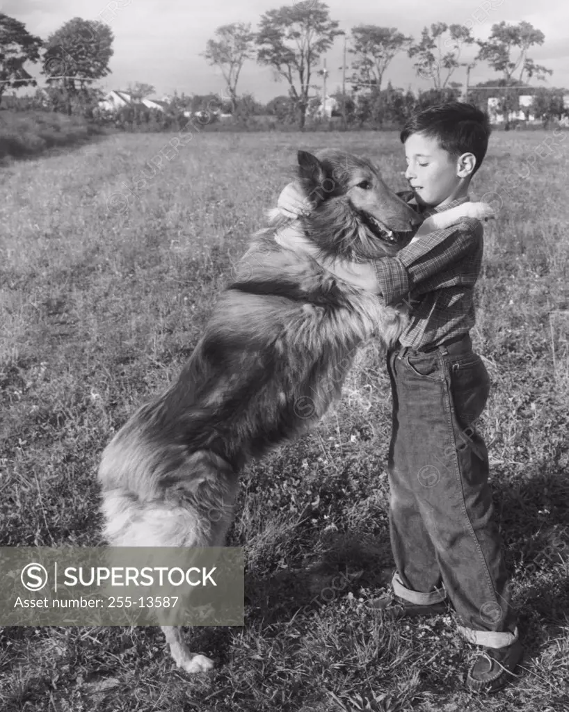 Side profile of boy playing with his dog