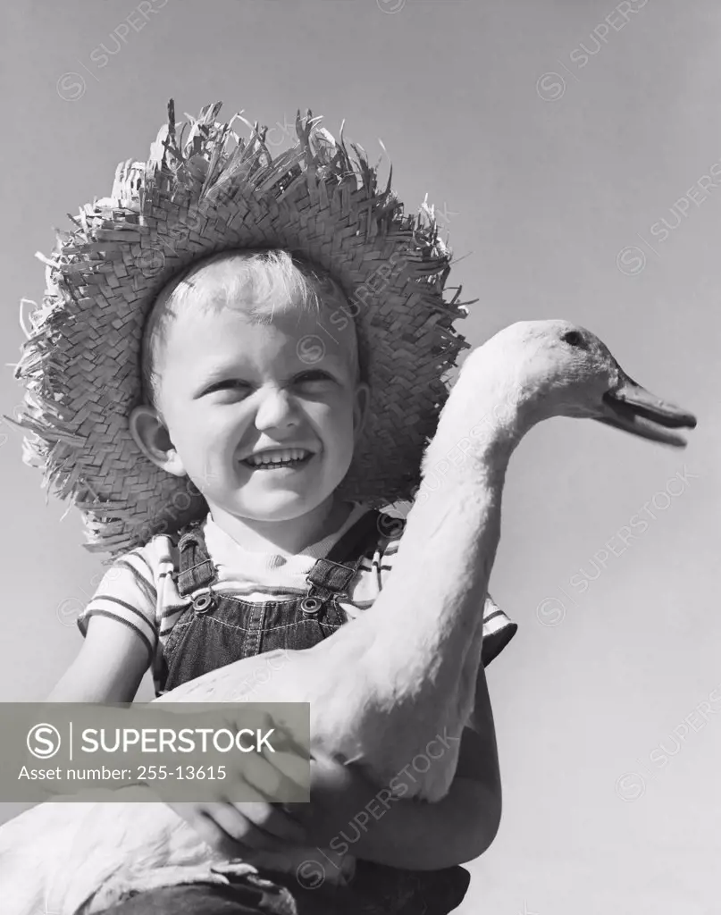 Close-up of a boy holding a duck and smiling