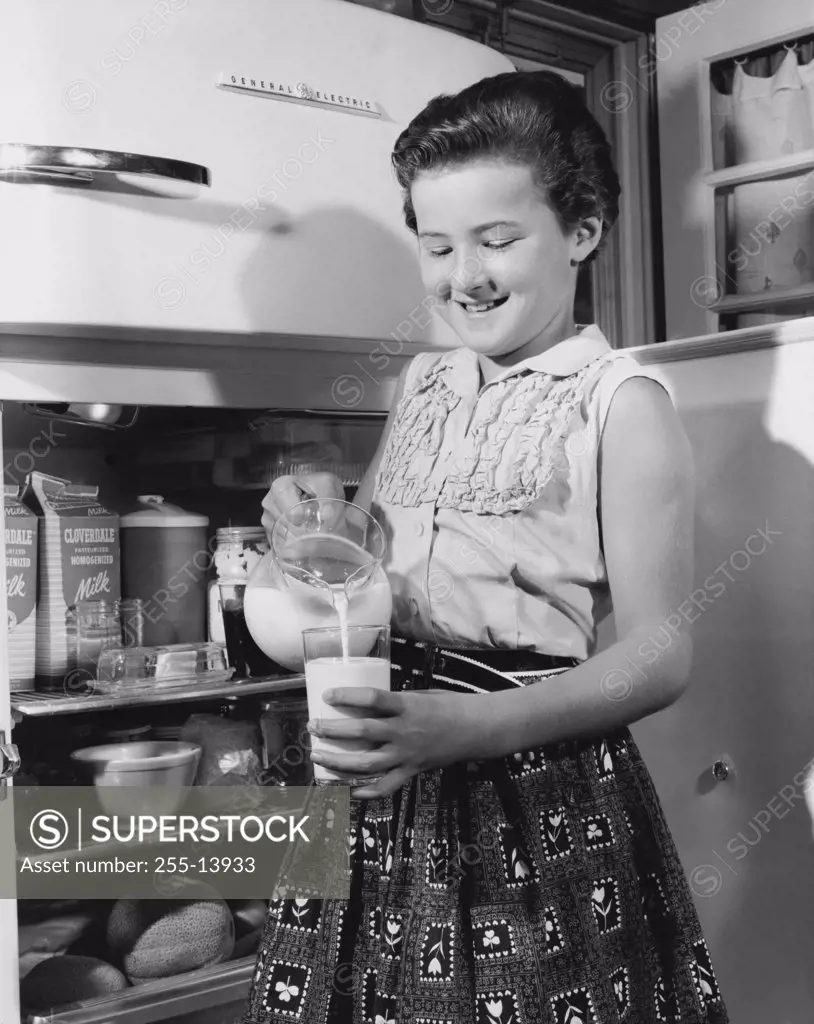Girl pouring milk into a glass
