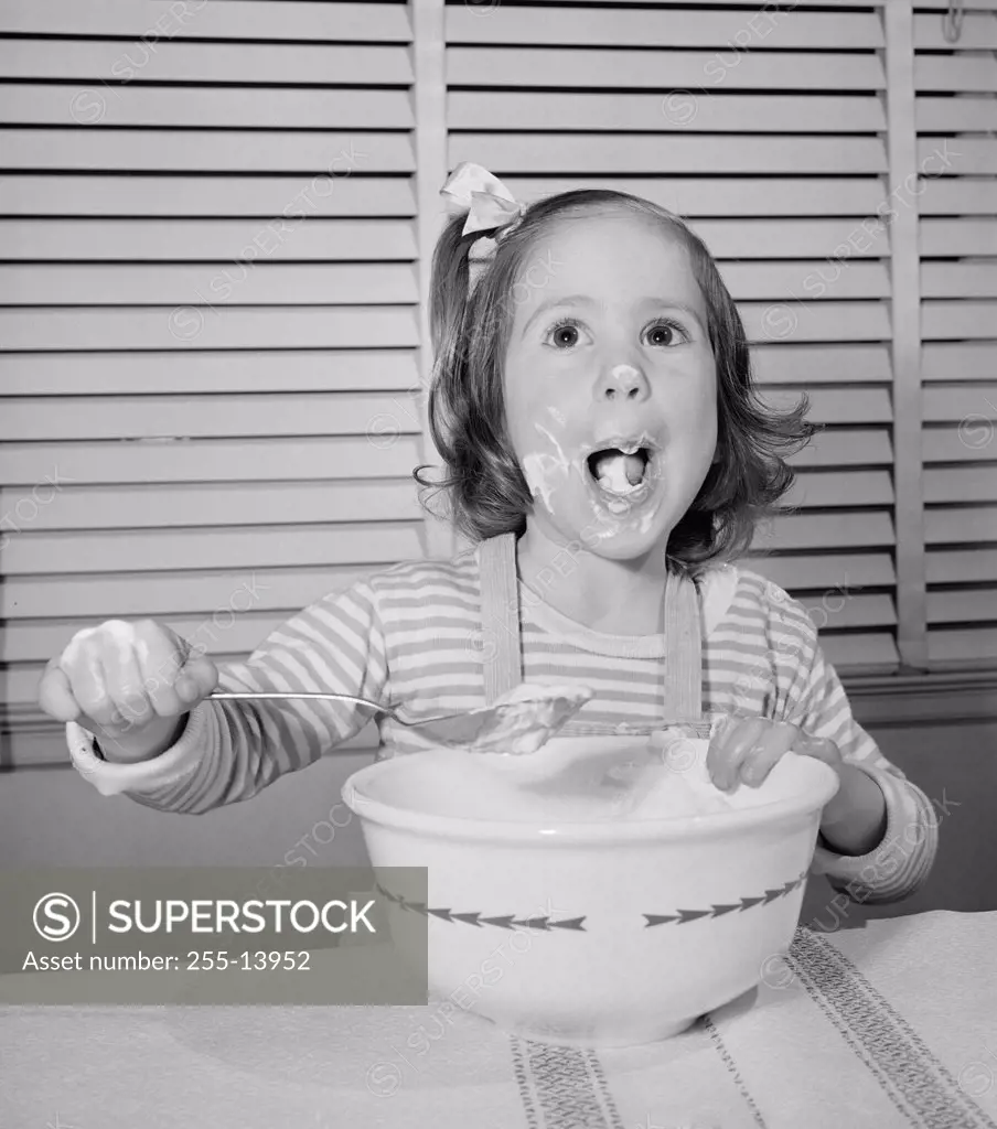 Close-up of a girl eating with a large spoon