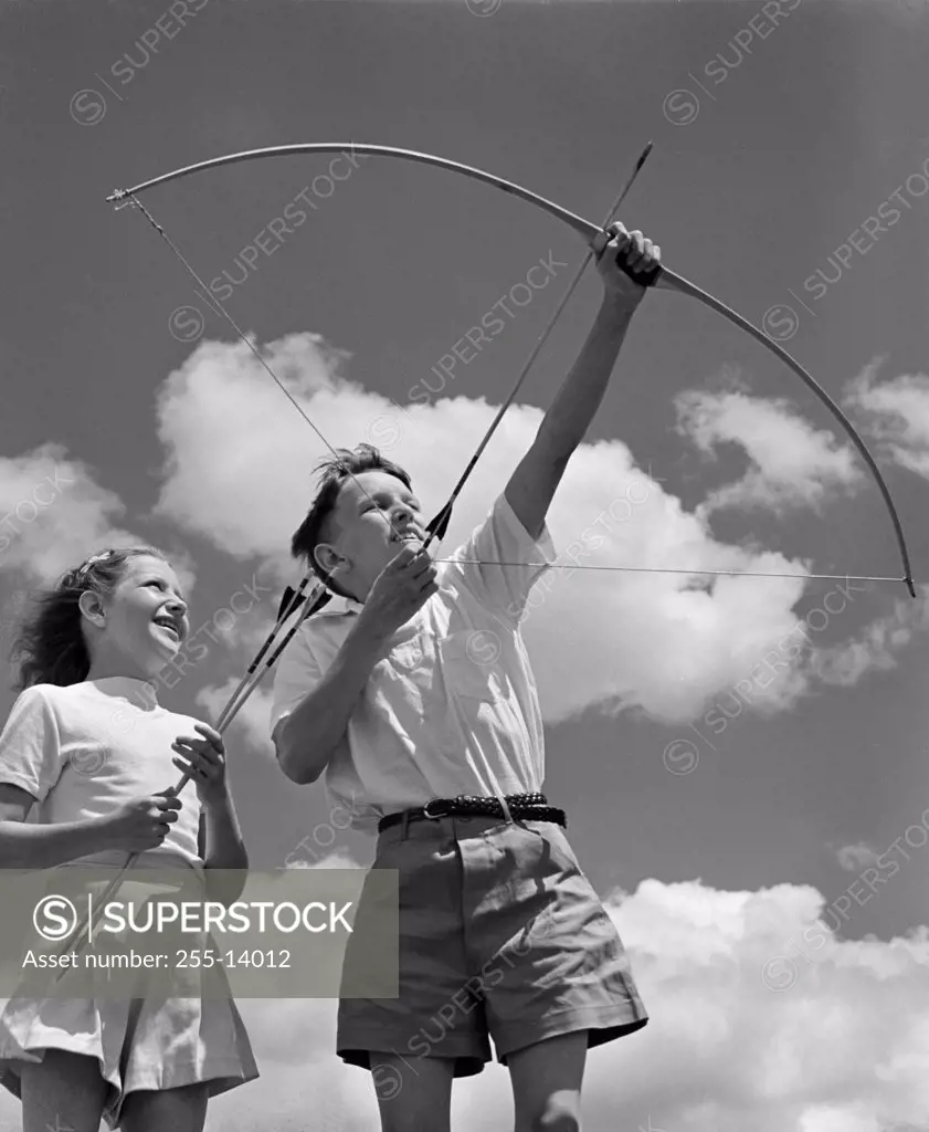 Boy and girl shooting with bow