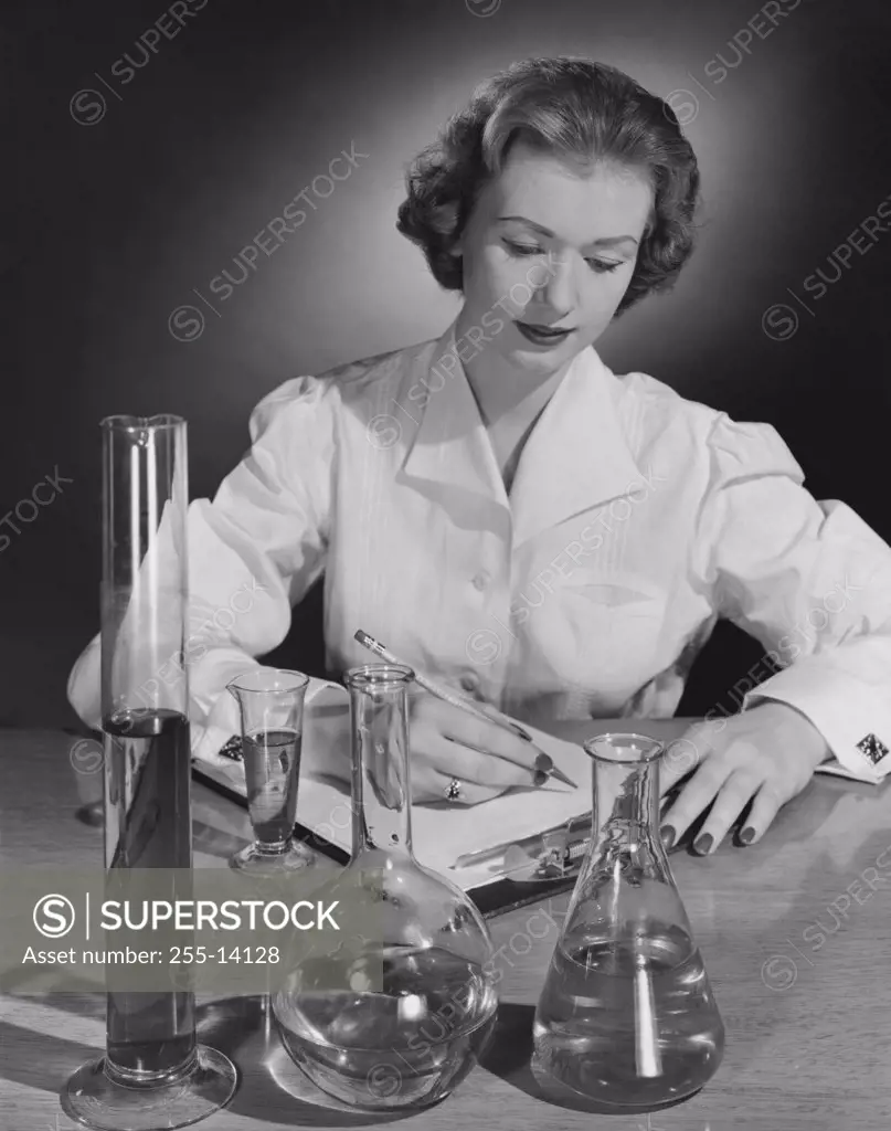Female scientist writing on a clipboard in a laboratory