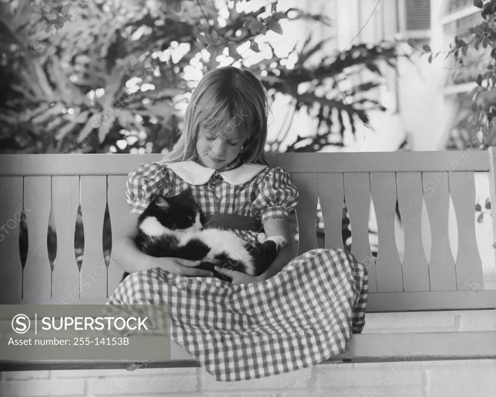 Girl sitting on a bench holding her cat