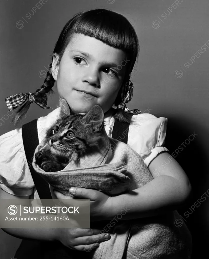 Studio shot of girl holding cat