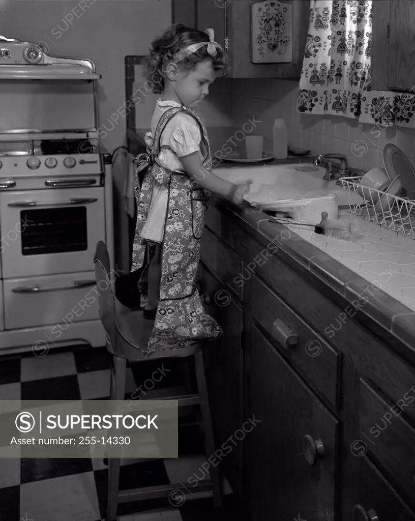 Girl washing up in kitchen