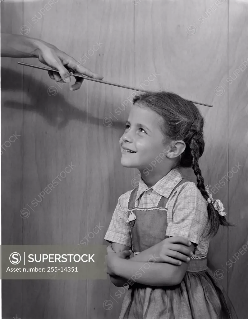 Woman measuring girls height with ruler 