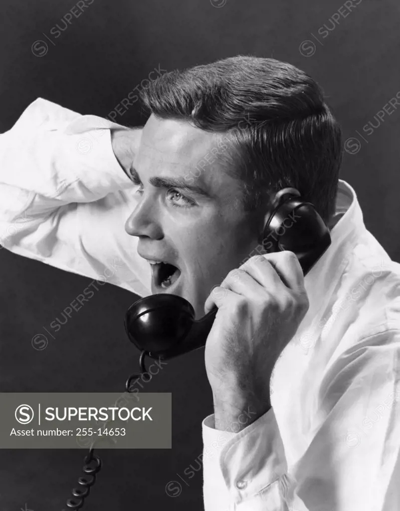 Close-up of a young man shouting on the telephone