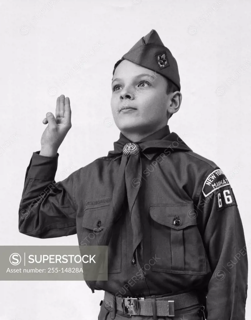 Close-up of a boy in a scout uniform saluting