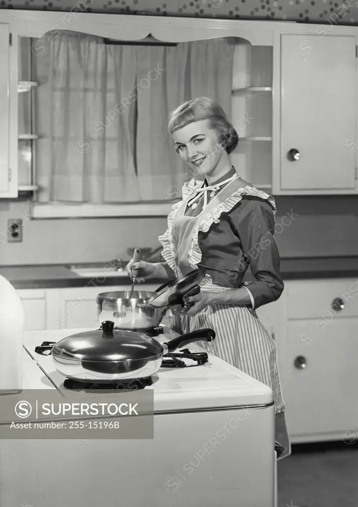 Vintage Photograph. Woman in apron preparing dinner in kitchen. Frame 3