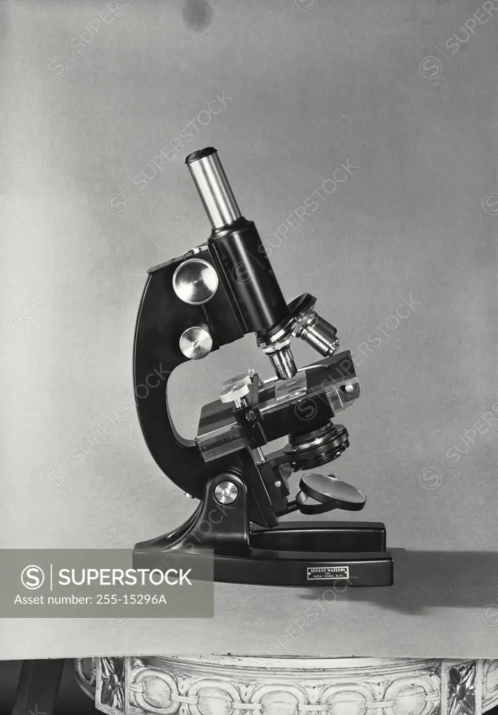 Vintage Photograph. Bausch and Lomb Microscope sitting on solid light background, viewed from right side