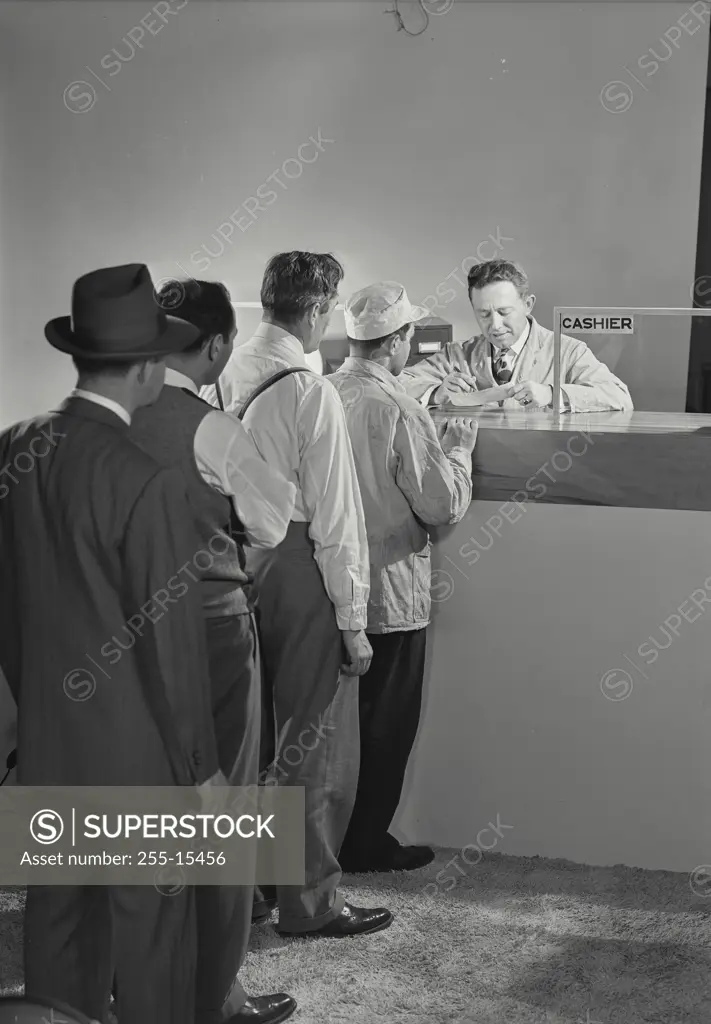 Vintage Photograph. Men standing in line waiting for the cashier.