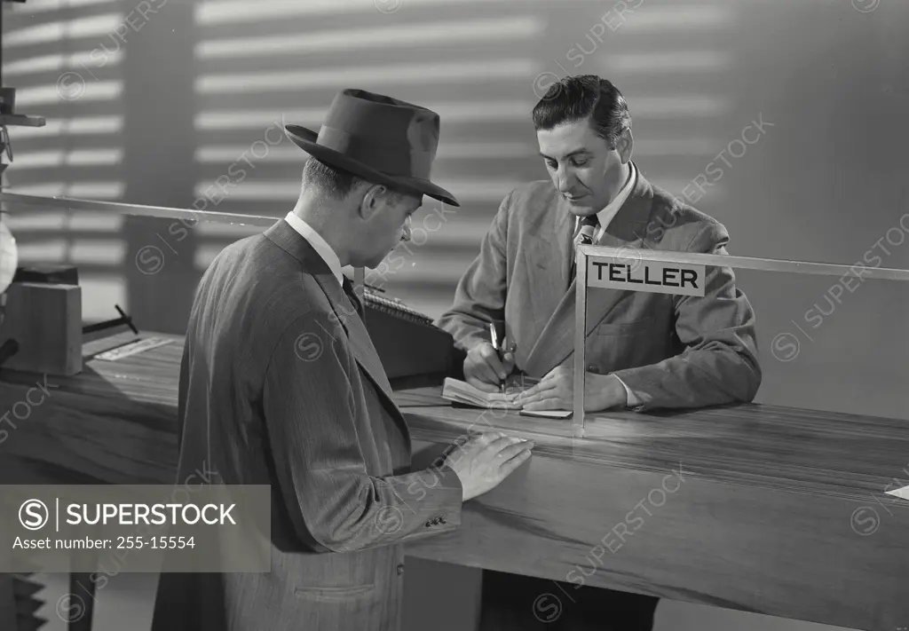 Vintage Photograph. Man at bank speaking with bank teller