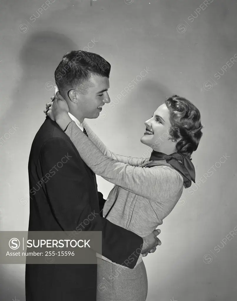 Vintage Photograph. Male female couple looking into each others eyes, arms wrapped around each other