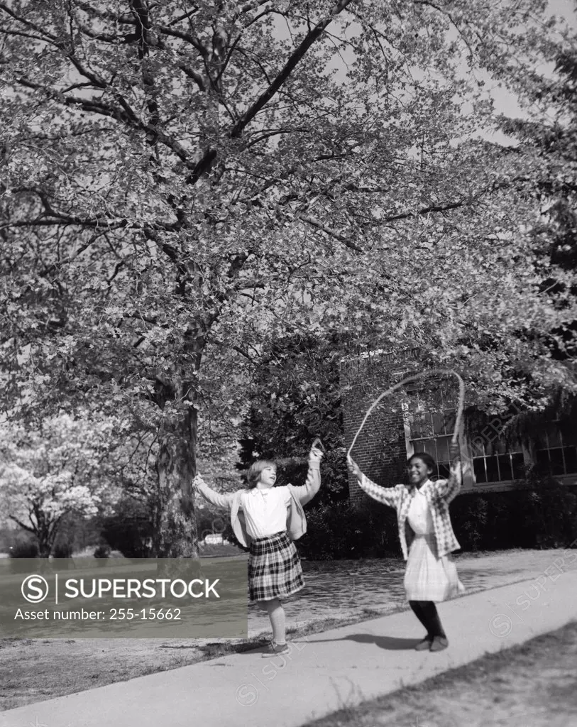 Vintage photograph of girls jumping with jump-rope in park