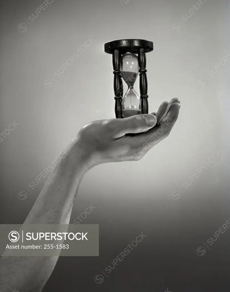 Hand holding hourglass
