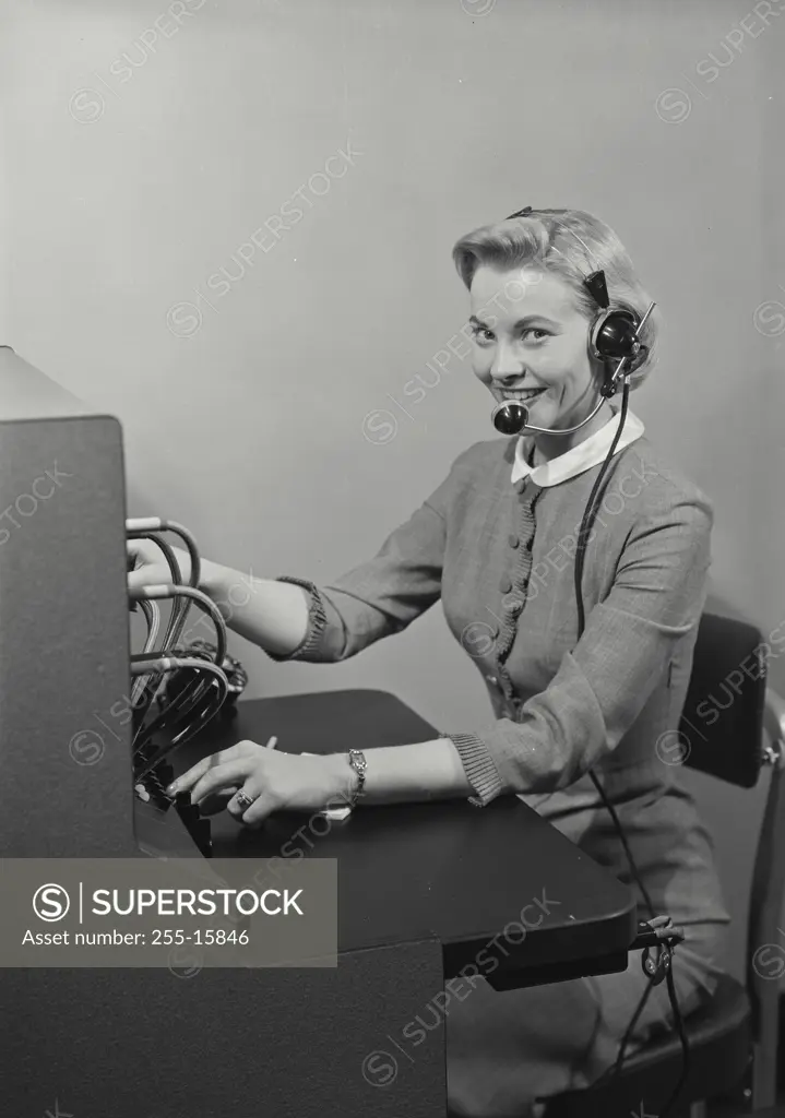 Vintage Photograph. Blonde woman switchboard operator smiling wearing headset and writing in notepad, Frame 11