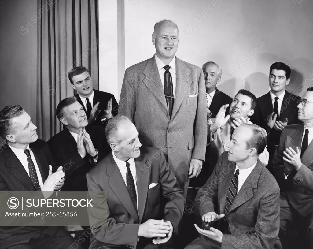 Group of businessmen applauding their colleague