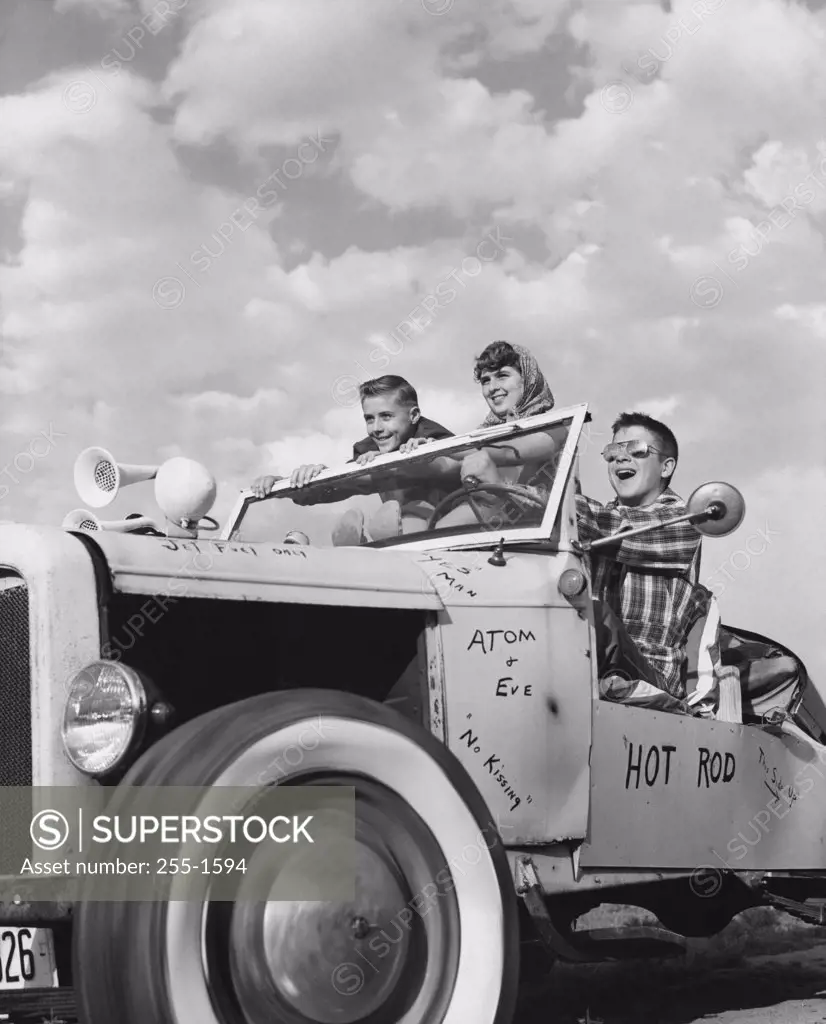 Low angle view of teenagers sitting in a vintage car