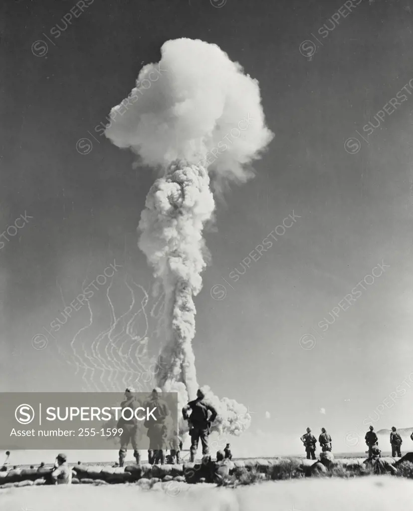 Vintage photograph. Atomic blast at Nevada Proving Grounds. Marines jump out of foxholes to watch an atomic cloud surge skyward during exercises