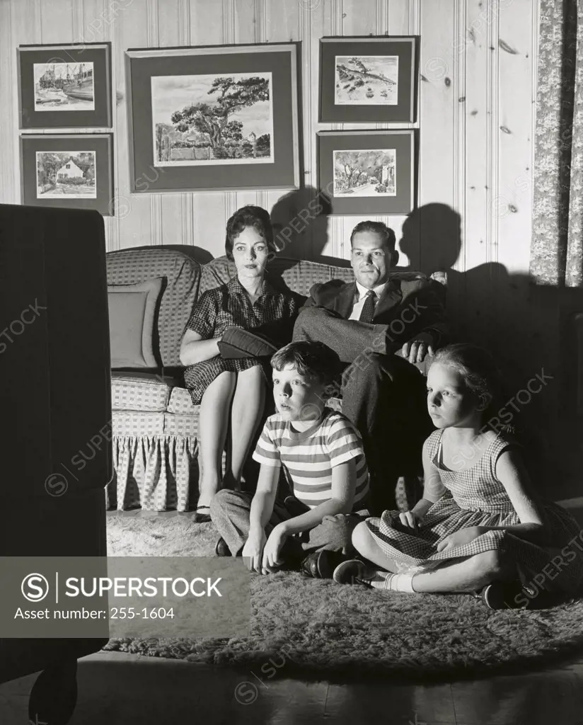 Family watching television in the living room