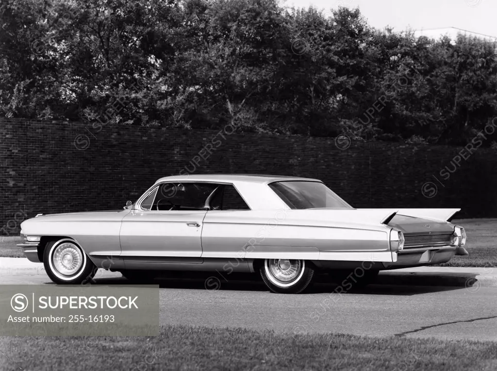 Side profile of a coupe parked on a road, 1962 Cadillac Series 62