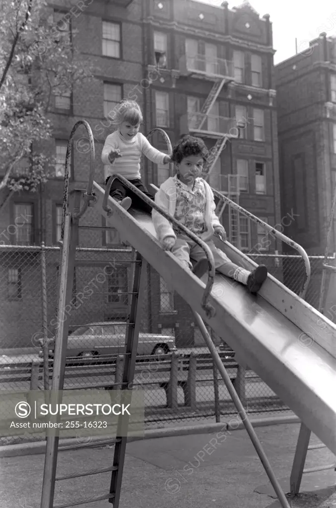 USA, New York City, New York, Children on slide in front of apartment building