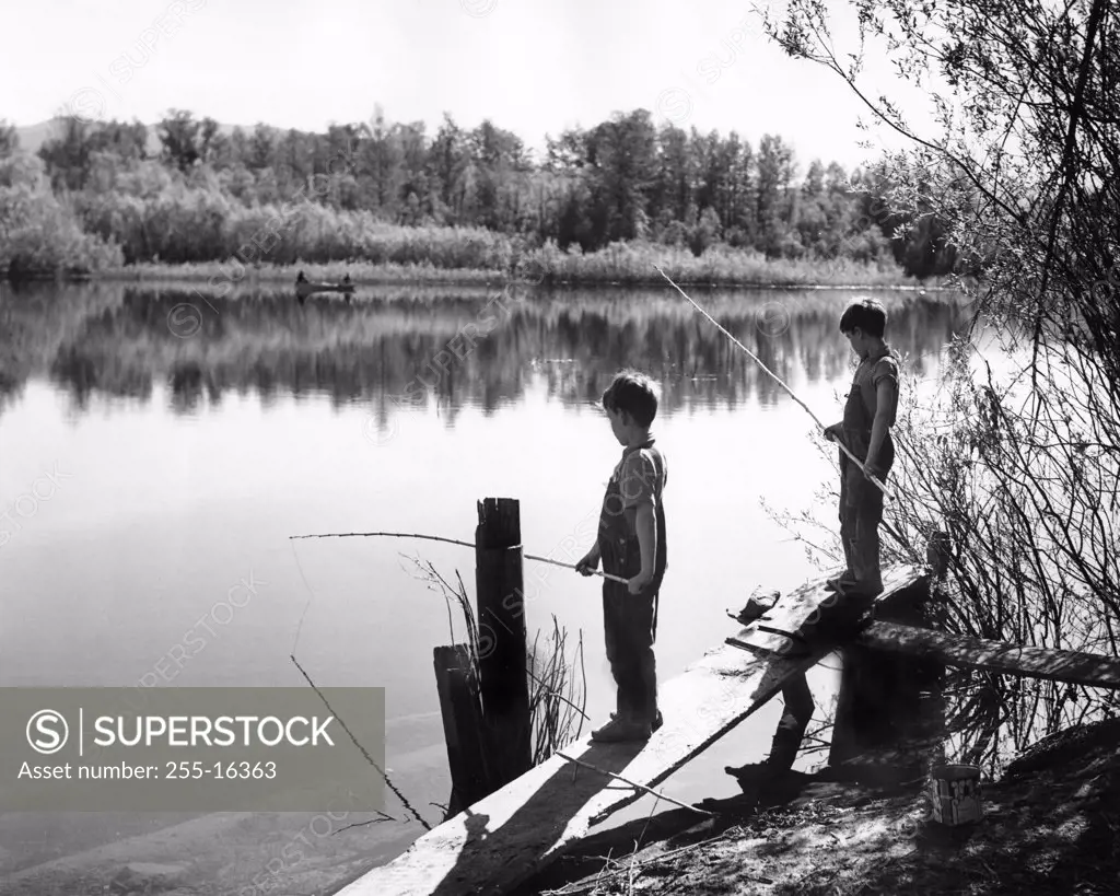 Two boys fishing in lake