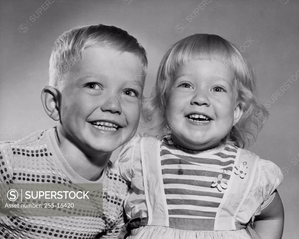 Close-up of a boy and his sister smiling