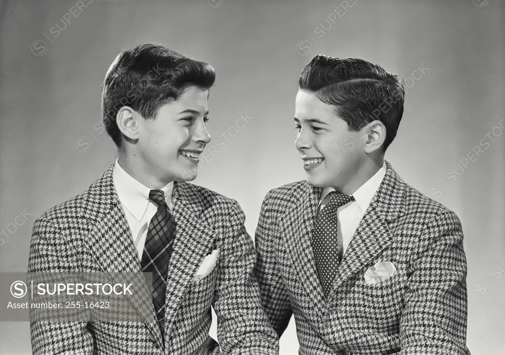 Vintage Photograph. Two boys in suits smiling at each other