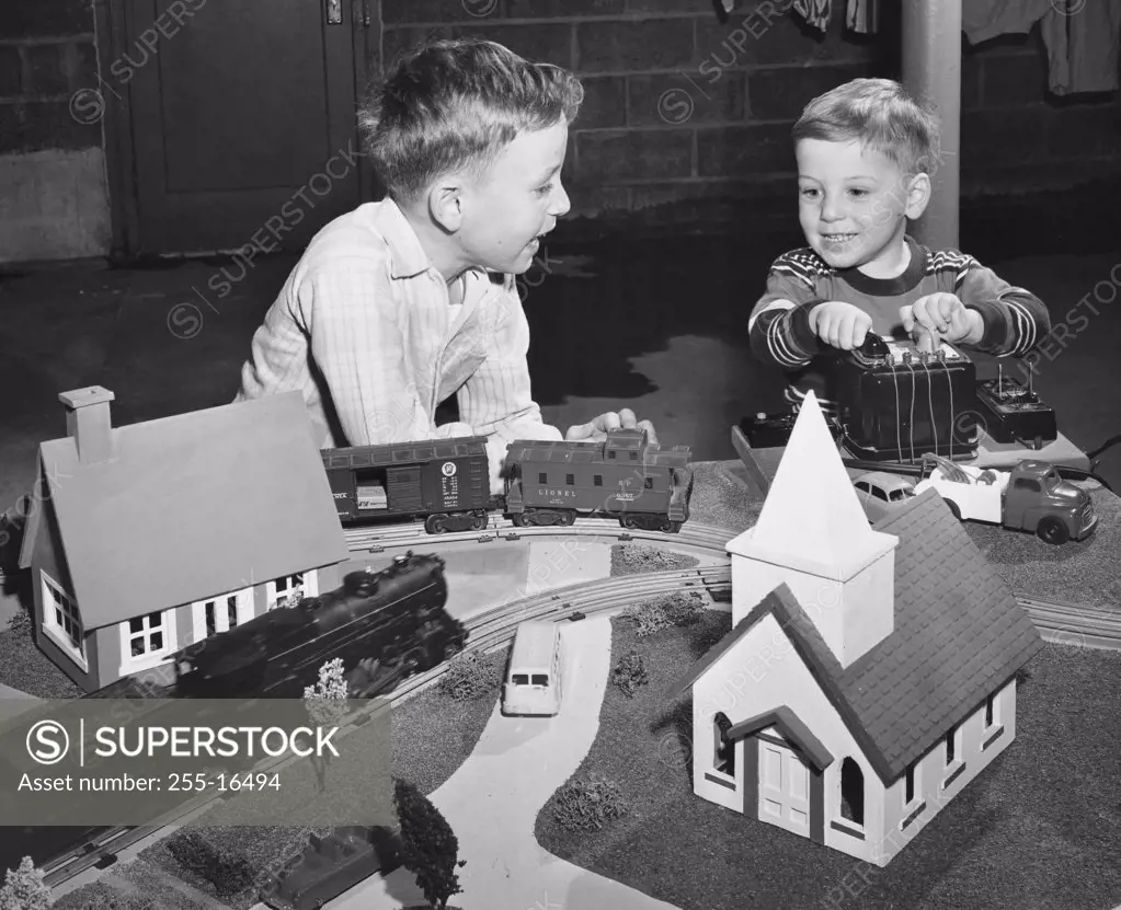 Two boys playing with a train set