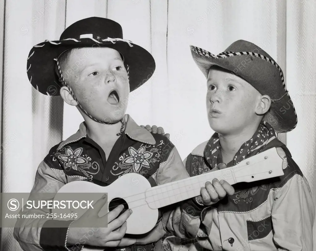 Two boys in cowboy costumes performing on stage