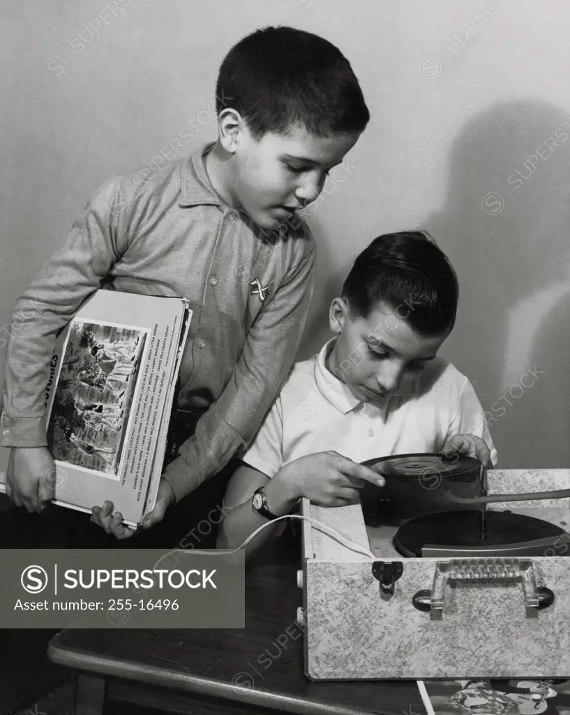 Two boys looking at a record