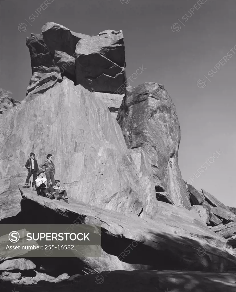 Low angle view of four boys on a rock, California, USA
