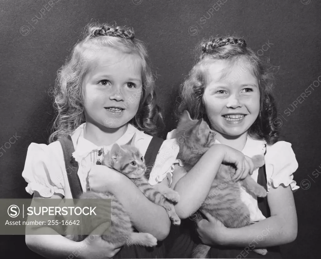 Two girls holding kittens