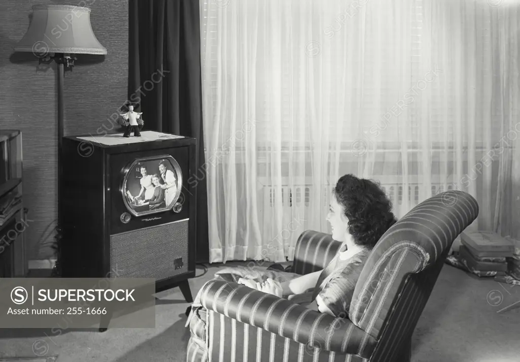 Vintage Photograph. Woman sitting in chair watching television.