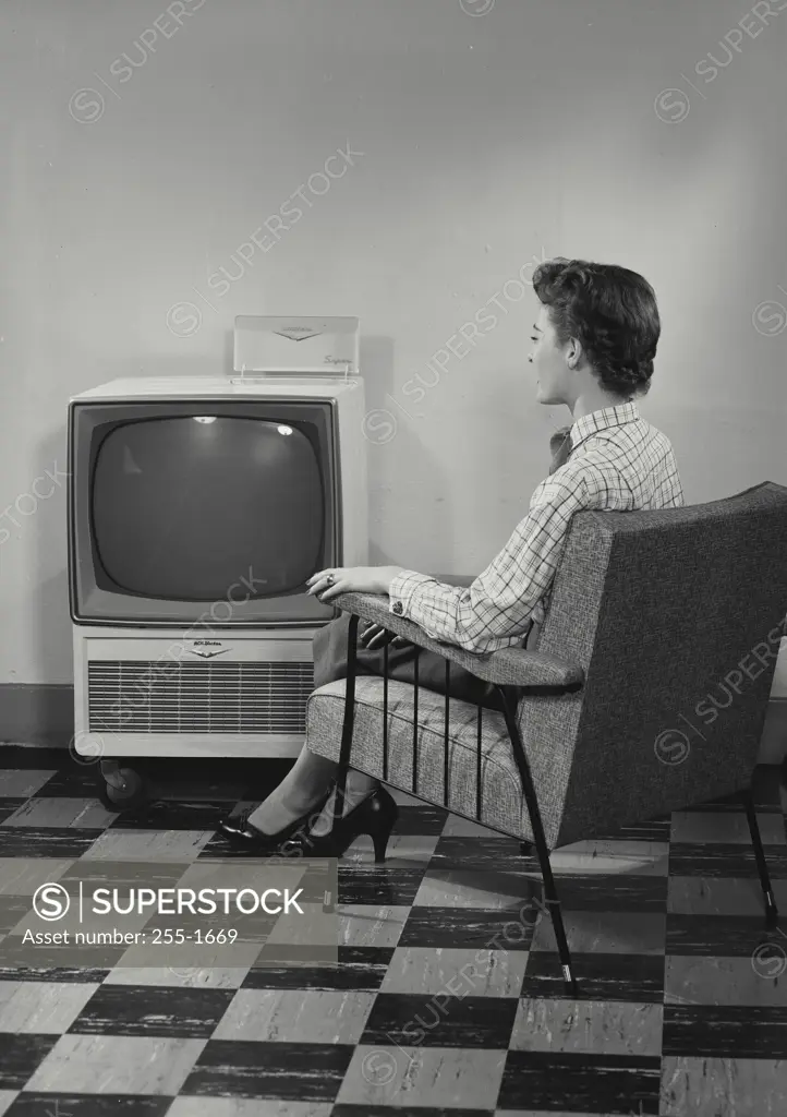 Vintage Photograph. Woman sitting in armchair in front of RCA Victor Television set
