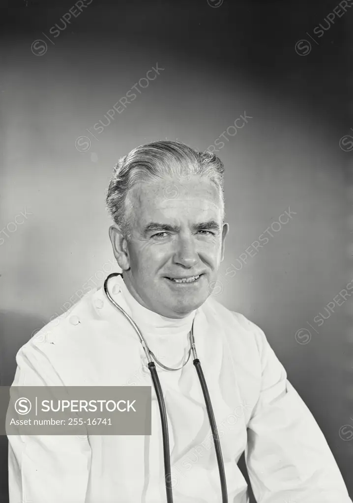 Vintage Photograph. Smiling man in white doctor uniform with stethoscope around neck