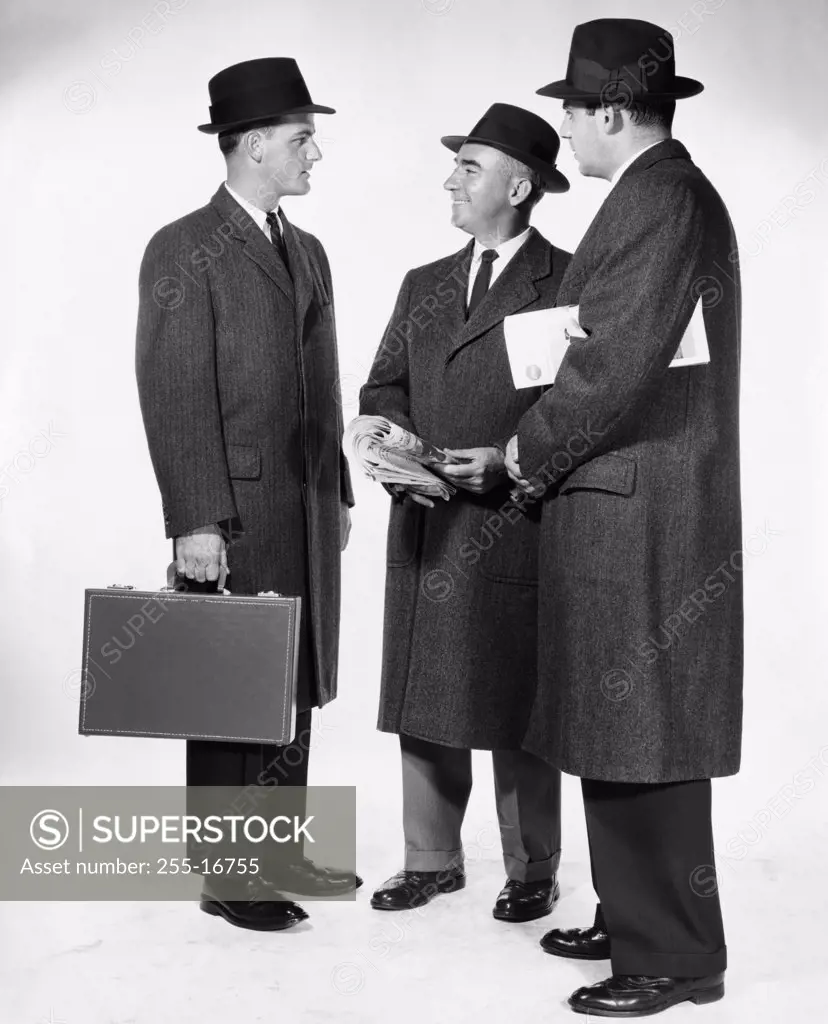Three businessmen talking to each other