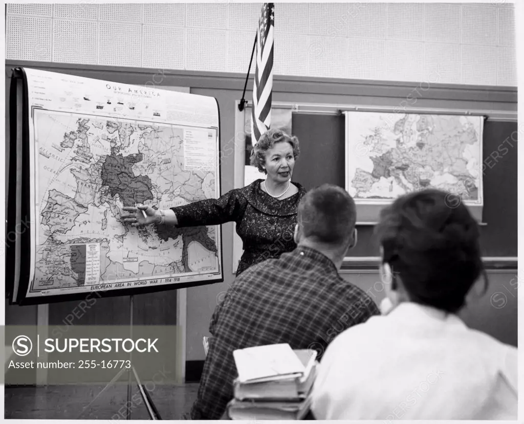 Female teacher pointing to a map in a classroom