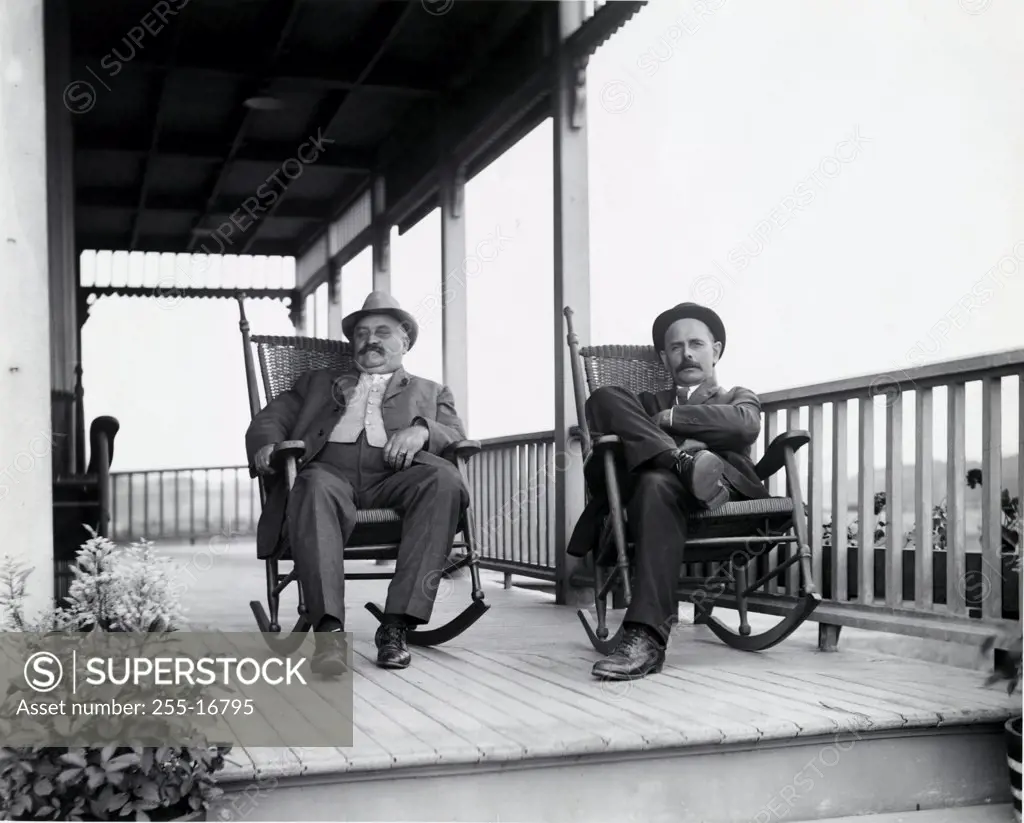Portrait of two mature men sitting on rocking chairs